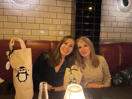 Emma and Karen sat in a restaurant with personalised bags